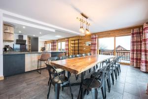 een keuken en eetkamer met een houten tafel en stoelen bij Chalet Salt Lake in La Toussuire