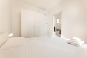 een witte slaapkamer met een groot bed met handdoeken erop bij Appartamento Marinaia Panorama in Marittima