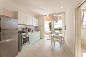 een keuken met witte kasten, een tafel en een fornuis bij Appartamento Marinaia Panorama in Marittima