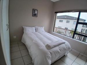 a white bed in a room with a window at 54 Topanga Holiday Accommodation in Margate