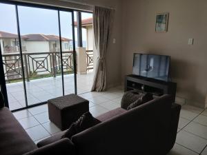 a living room with a couch and a flat screen tv at 54 Topanga Holiday Accommodation in Margate
