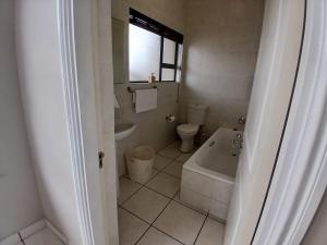 a bathroom with a tub and a toilet and a sink at 54 Topanga Holiday Accommodation in Margate +14 photos