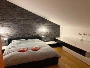 a bedroom with a bed with two red towels on it at Home Little Star in Gorizia