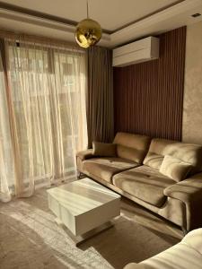 een woonkamer met een bank en een salontafel bij Апартамент AZUR PREMIUM in Varna