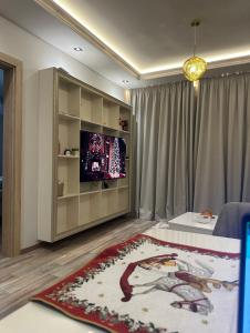 een woonkamer met een televisie en een tapijt bij Апартамент AZUR PREMIUM in Varna