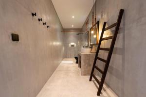 a staircase in a bathroom with a sink and a toilet at Kano Uluwatu in Uluwatu +19 photos