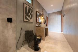 a bathroom with a toilet and a sink at Kano Uluwatu in Uluwatu