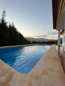 a swimming pool next to a house at Casa de mis sueños Castril in El Batán