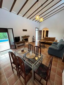 a living room with a glass table and chairs at Casa de mis sueños Castril in El Batán