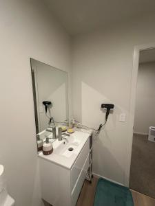 a white bathroom with a sink and a mirror at Double Bedroom in Newly Built Townhouse in Wallaceville +2 photos