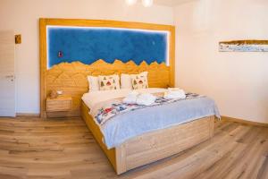 ein Schlafzimmer mit einem großen Bett mit einem hölzernen Kopfteil in der Unterkunft Antico Borgo in Longarone