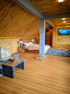 a bedroom with two beds and a table in a room at Bagas Luxury Camp in Kejajar