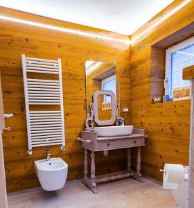 ein Holzbadezimmer mit einem Waschbecken und einem Spiegel in der Unterkunft Antico Borgo in Longarone + 41 Fotos