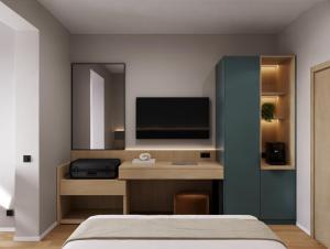Un dormitorio con una cama y un televisor en una pared. en Tailormade Hotel AL GIARDINETTO Biasca, en Biasca