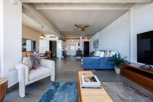 Una sala de estar con un sofá azul y un televisor en Atlantis 18 Breathtaking View Apt in San Juan, en San Juan