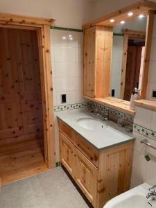 un baño con lavabo y espejo en 2,5 Zimmer Wohnung mit Bergblick in Engadin, en Zuoz