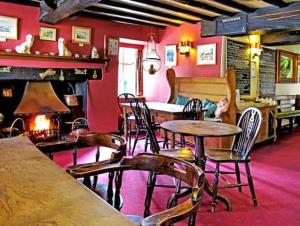 ein Zimmer mit Tischen und Stühlen und einem Kamin in der Unterkunft Wild Valley Bunkhouse in Llanrhaeadr-ym-Mochnant + 20 Fotos