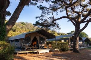 Un camping con dos tiendas de campaña bajo los árboles. en Camping RCN Port l'Epine, en Trélévern