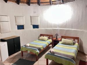 una stanza con due letti e una finestra di Nut Tree Nook a Hazyview