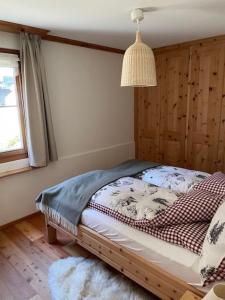 Un dormitorio con una cama en una habitación con ventana. en 2,5 Zimmer Wohnung mit Bergblick in Engadin, en Zuoz