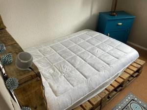 een bed in een kamer met een blauwe kast bij Maison confortable avec terrasse à Courseulles-sur-Mer in Courseulles-sur-Mer