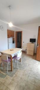 una cucina con un tavolo e sedie in una stanza di Casa Kalida a Santa Maria a Potenza Altre 7 foto