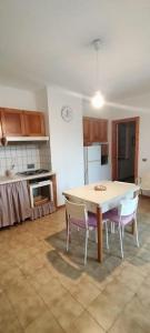 una cucina con un tavolo e sedie in una stanza di Casa Kalida a Santa Maria a Potenza