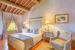 a bedroom with a bed and a chair at VILLA PITTI AMERIGHI 26, Emma Villas in Pieve a Nievole +56 photos