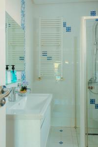 Villa Le Grand Bleu في ميدون: حمام أبيض مع حوض ودش