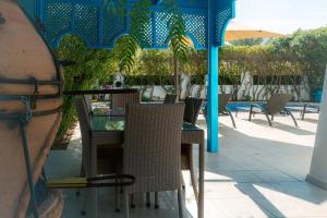 Villa Le Grand Bleu في ميدون: طاولة وكراسي يجلسون تحت شرفة