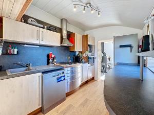 a kitchen with stainless steel appliances and wooden cabinets at Dune Marchande - Séjour Cozy in Bray-Dunes