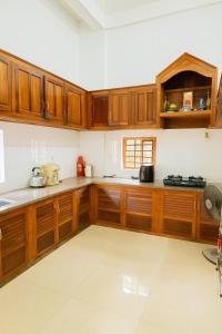 a kitchen with wooden cabinets and a counter top at Sim House in Hue