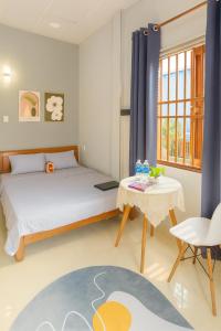 a bedroom with a bed and a table at Sim House in Hue