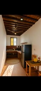 Villa-Katerina-paje Zanzibar apartment في Kiganga: مطبخ مع ثلاجة ستانلس ستيل وطاولة