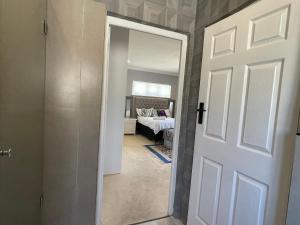 Blouberg kiters في Cape Town: ممر به باب يؤدي إلى غرفة نوم