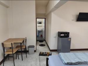 乌汶Doctor Thanut Hostel的小房间设有桌子和桌椅