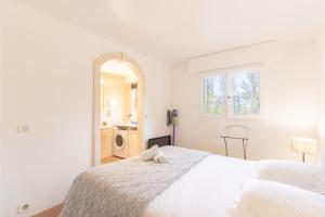 a white bedroom with a bed and a mirror at Le Sommet du Large - Terrasse - Vue Mer - Parking Privé in Trouville-sur-Mer