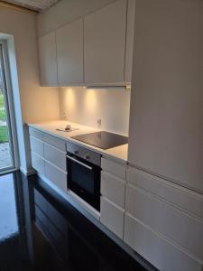 une cuisine avec des armoires blanches et un four à plaques de cuisson dans l'établissement Copenhagen Comfort, à Copenhague