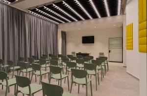 a conference room with chairs and a podium and a screen at Cora Sun Apart-Hotel in St Paul's Bay