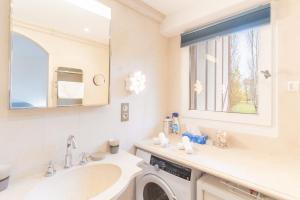 a bathroom with a washing machine and a sink at Le Sommet du Large - Terrasse - Vue Mer - Parking Privé in Trouville-sur-Mer