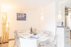 a white dining room table with white chairs and a white refrigerator at Le Sommet du Large - Terrasse - Vue Mer - Parking Privé in Trouville-sur-Mer +7 photos