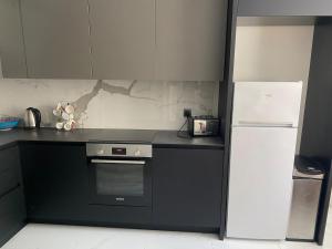 a kitchen with a stove and a refrigerator in it at Angenellyq apartment in Kyustendil +12 photos