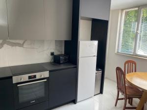 a kitchen with a white refrigerator and a table at Angenellyq apartment in Kyustendil