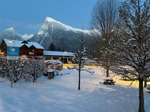 a lodge in the snow with mountains in the background at Chalet des Cinq in Samoëns
