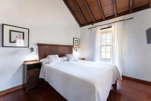 a bedroom with a white bed and a window at GuestReady - Hotel Rural Las Calas in Vega de San Mateo +22 photos