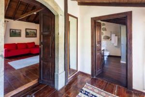 a living room with a red couch and an open door at GuestReady - Hotel Rural Las Calas in Vega de San Mateo