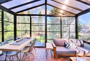 a large conservatory with a couch and a table and chairs at Spa - Waterfront - Le Nordika in Valcartier Station