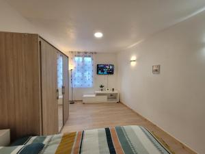 a bedroom with a bed and a television on a wall at Appartement entier au rez- de- chaussée 