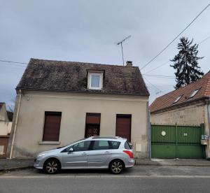 a silver car parked in front of a house at Appartement entier au rez- de- chaussée 