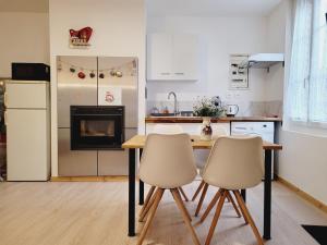 a kitchen with a table and two chairs at Appartement entier au rez- de- chaussée 